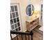 A decorative table in a foyer with a round mirror hanging above it at 115 Morrocroft Ln, Mooresville, NC 28117