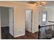 Second floor hallway features three doors and stylish lighting, complemented by wood flooring at 115 Morrocroft Ln, Mooresville, NC 28117