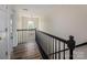 Bright hallway features hardwood floors, black railing, and natural light from an arched window at 115 Morrocroft Ln, Mooresville, NC 28117