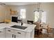 Modern kitchen featuring white cabinets, a marble countertop, and an adjacent dining area with stylish furniture at 115 Morrocroft Ln, Mooresville, NC 28117