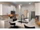 Modern kitchen with white cabinets, a black faucet, and a beautiful backsplash, perfect for cooking and entertaining at 115 Morrocroft Ln, Mooresville, NC 28117