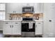 Stylish kitchen features white cabinetry, stainless steel appliances, and a decorative backsplash at 115 Morrocroft Ln, Mooresville, NC 28117