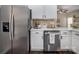Kitchen with stainless steel appliances, white cabinets, and a neutral-toned backsplash at 115 Morrocroft Ln, Mooresville, NC 28117