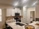 Kitchen with white cabinets, stainless steel appliances, and a view to an adjacent room, creating an open and inviting space at 115 Morrocroft Ln, Mooresville, NC 28117