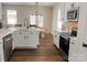Bright kitchen with stainless steel appliances, white cabinets, and a view to a dining table and chairs at 115 Morrocroft Ln, Mooresville, NC 28117