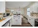 Bright kitchen showcasing white cabinets, marble countertops, and an open view into the dining area at 115 Morrocroft Ln, Mooresville, NC 28117