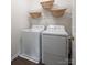 Functional laundry area equipped with white washer and dryer and shelving at 115 Morrocroft Ln, Mooresville, NC 28117