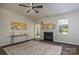 Open living room with fireplace, ceiling fan, and doorway to dining room at 115 Morrocroft Ln, Mooresville, NC 28117