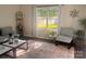 Cozy living room with large windows, providing natural light, with comfortable seating and a modern ceiling fan at 115 Morrocroft Ln, Mooresville, NC 28117
