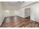 Bright main bedroom with tray ceiling, wood-look floors, and double doors to an en suite bathroom at 115 Morrocroft Ln, Mooresville, NC 28117