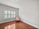 Bedroom with hardwood floors, large window with shutters, and an accent chair at 1169 Stuarts Landing Dr, Cramerton, NC 28032