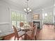 Cozy dining room with hardwood floors, a modern chandelier, and a view of the fireplace at 1169 Stuarts Landing Dr, Cramerton, NC 28032