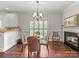 Inviting dining area with hardwood floors, fireplace, and natural light from a nearby window at 1169 Stuarts Landing Dr, Cramerton, NC 28032