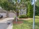 Well-manicured front yard with mature tree, two-car garage, and stone accents on the facade at 1169 Stuarts Landing Dr, Cramerton, NC 28032