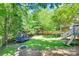 Spacious backyard featuring a trampoline, swing, wooden fence, green grass, and a deck with stairs at 12004 Woodholm Ct, Tega Cay, SC 29708