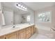 Bright bathroom featuring double sinks, a large mirror, a bathtub, and natural light from a window at 12004 Woodholm Ct, Tega Cay, SC 29708