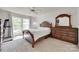 A primary bedroom with a wooden bed frame, large windows and natural lighting, showcasing cozy interior at 12004 Woodholm Ct, Tega Cay, SC 29708