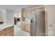 Traditional kitchen featuring wooden cabinets and stainless steel refrigerator, with an open view to the living room at 12004 Woodholm Ct, Tega Cay, SC 29708