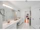 Bright bathroom featuring double sinks, vanity, and large mirror at 12416 Stirling Trace Ct, Charlotte, NC 28277