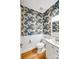 Stylish half bath with patterned wallpaper, wainscoting, and modern fixtures at 12416 Stirling Trace Ct, Charlotte, NC 28277