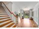 Bright foyer features hardwood floors, staircase, and an open doorway to the exterior at 12416 Stirling Trace Ct, Charlotte, NC 28277