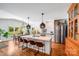 Open concept kitchen and dining area with island, hardwood floors, stainless appliances, and large windows at 12416 Stirling Trace Ct, Charlotte, NC 28277
