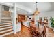 Open-concept kitchen and dining room with hardwood floors, a kitchen island, and stairs to the upper level at 12416 Stirling Trace Ct, Charlotte, NC 28277