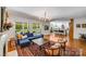 Open floor plan with hardwood floors connecting the living room, kitchen, and backyard views at 12416 Stirling Trace Ct, Charlotte, NC 28277