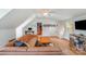 Spacious living room features a leather couch, hardwood floors, and access to the stairs at 12416 Stirling Trace Ct, Charlotte, NC 28277