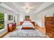 Tranquil main bedroom features a tray ceiling, ceiling fan, and wood furniture at 12416 Stirling Trace Ct, Charlotte, NC 28277