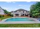 Back of house and in-ground pool, with a large deck, grassy yard, and mature trees at 12416 Stirling Trace Ct, Charlotte, NC 28277