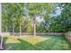 Large, level back yard with mature trees and lawn surrounded by a wooden fence at 12434 Sylvan Oak Way, Charlotte, NC 28273