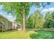 Expansive back yard with large trees and full lawn with a deck off the rear of the home at 12434 Sylvan Oak Way, Charlotte, NC 28273