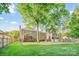 Large, green backyard with a fence and mature trees provides a private and inviting outdoor space at 12434 Sylvan Oak Way, Charlotte, NC 28273
