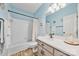 Bright bathroom features a shower and tub, a vanity with modern fixtures, and light blue walls at 12434 Sylvan Oak Way, Charlotte, NC 28273