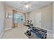 Neutral bedroom with ceiling fan, bright windows, and home exercise equipment at 12434 Sylvan Oak Way, Charlotte, NC 28273