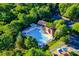 Aerial view of community pool, clubhouse, lounge chairs, umbrellas, and mature trees at 12434 Sylvan Oak Way, Charlotte, NC 28273