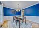 Stylish dining room with wainscoting, dark blue walls, and modern chandelier at 12434 Sylvan Oak Way, Charlotte, NC 28273