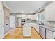 Spacious kitchen with white cabinets, stainless steel appliances, granite countertops and hardwood floors at 12434 Sylvan Oak Way, Charlotte, NC 28273