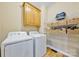 Functional laundry room with washer, dryer, overhead cabinets, and wire shelving for ample storage at 12434 Sylvan Oak Way, Charlotte, NC 28273