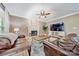 Comfortable living room featuring a fireplace, a ceiling fan, and leather sofas at 12434 Sylvan Oak Way, Charlotte, NC 28273
