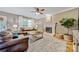 Cozy living room with hardwood floors, fireplace, ceiling fan, and comfortable seating at 12434 Sylvan Oak Way, Charlotte, NC 28273