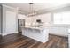 Kitchen featuring white cabinets, stainless steel appliances, a large center island, and dark wood floors at 14019 Cameryn Elise Dr, Cornelius, NC 28031
