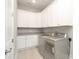 Bright laundry room with washer and dryer, white cabinets and light-colored granite countertop at 14019 Cameryn Elise Dr, Cornelius, NC 28031