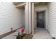Covered front entrance with a black front door and decorative flower pot at 14027 Clayborn St, Midland, NC 28107