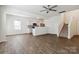 Spacious living room and staircase adjacent to an open kitchen, all enhanced with hardwood floors at 14027 Clayborn St, Midland, NC 28107