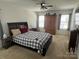 Comfortable bedroom with a plaid comforter, ceiling fan, and natural light from the windows at 15005 Savannah Hall Dr # 72, Charlotte, NC 28273