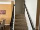 Carpeted staircase with dark wood railing and white walls leads to the upper level at 15005 Savannah Hall Dr # 72, Charlotte, NC 28273
