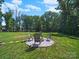Backyard with fire pit and seating; ideal for outdoor entertaining on a well-manicured lawn at 159 Autumn Mist Rd, Statesville, NC 28677
