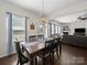 Inviting dining area features a wooden table, stylish light fixture, and flows into the living room, great for entertaining at 159 Autumn Mist Rd, Statesville, NC 28677